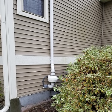 Radon mitigation system outside home.