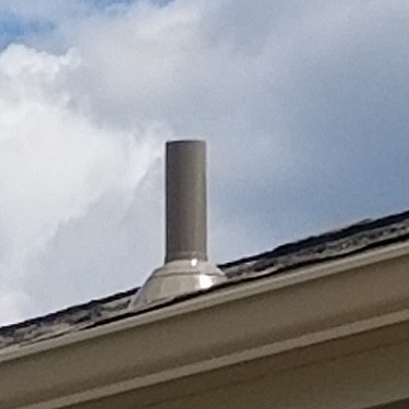 Radon mitigation system show pipe on top of house