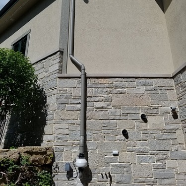 Radon mitigation system outside home.