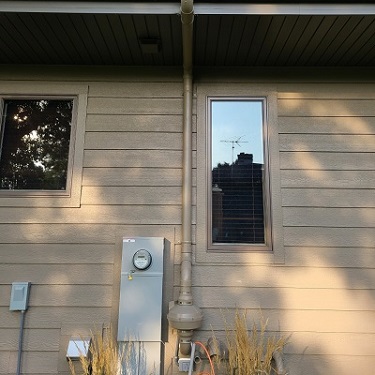 Radon mitigation system outside home.