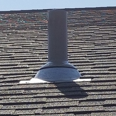 Radon mitigation system show pipe on top of house